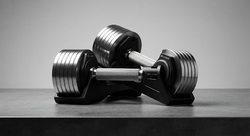 Editorial studio shot of premium adjustable dumbbells with knurled steel handles